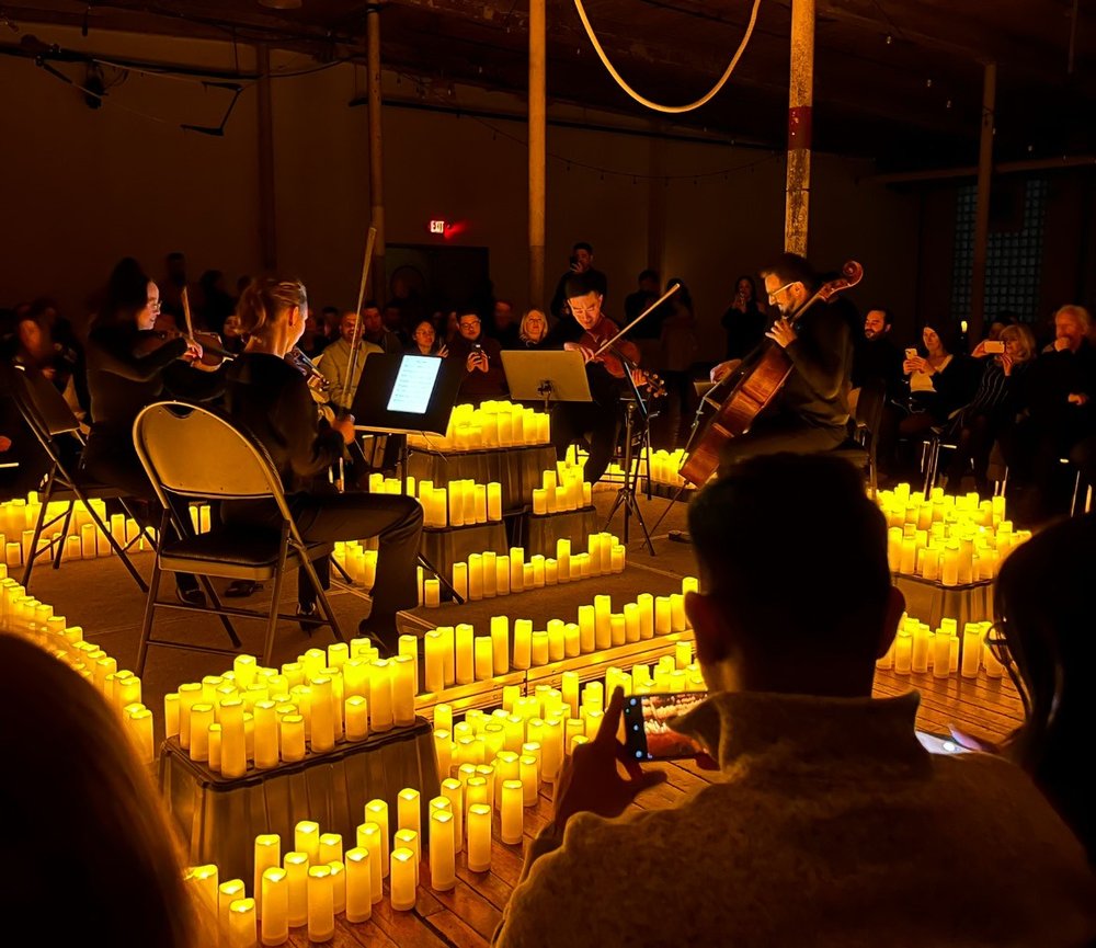 String Quartet surrounded by candles at the Cotton Factory during a performance.