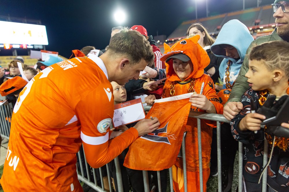 Forge FC player signing autographs.