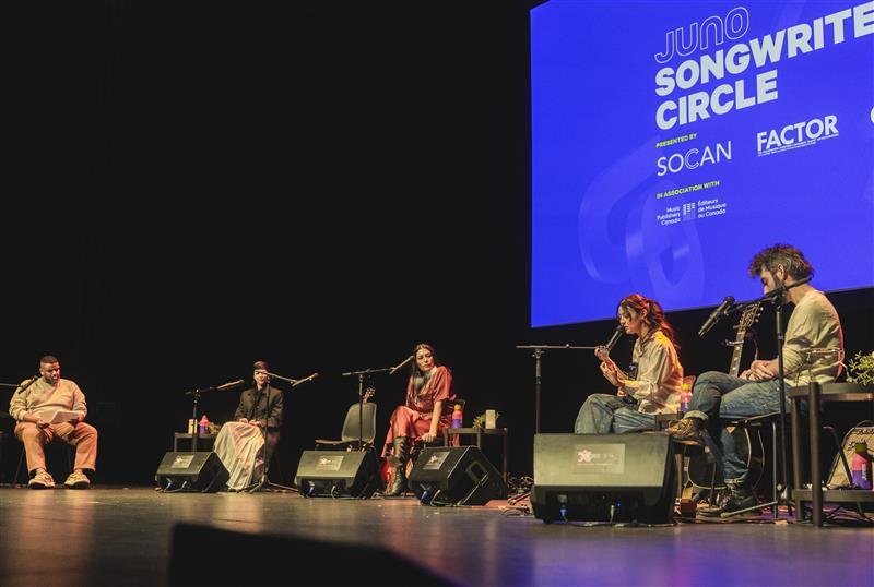 Musicians on stage with instruments.