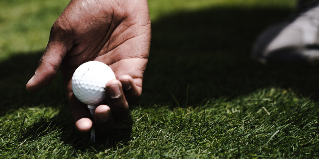 Golfer placing ball on tee