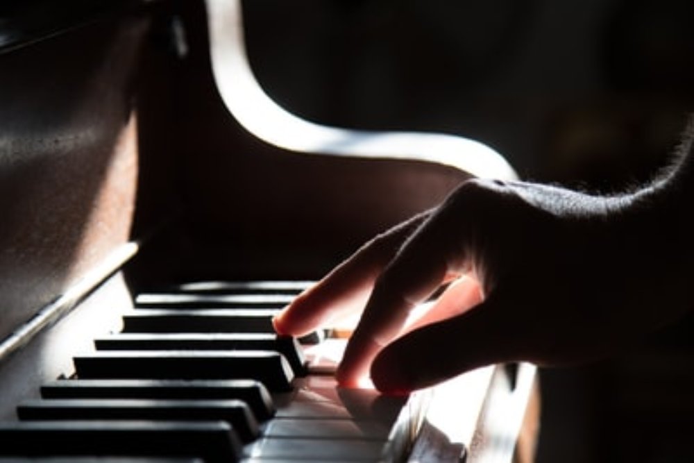 Up close image of a musician playing the piano.