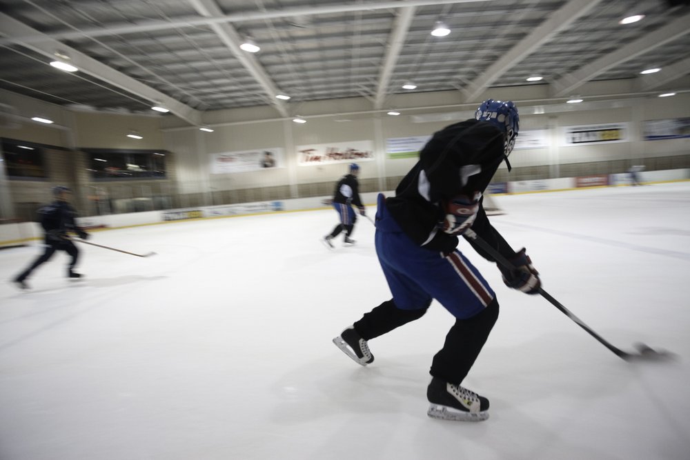 Hockey players skating across ice.