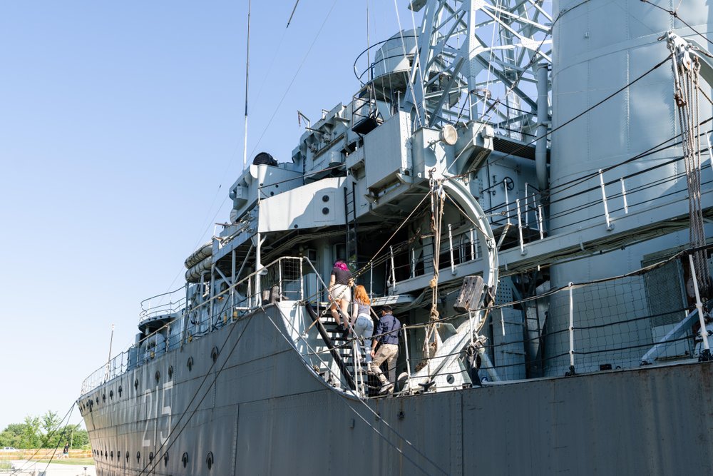 Group walking up the stairs of HMCS Haida.