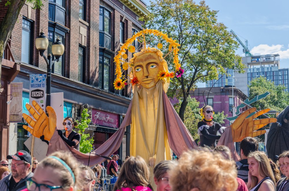 A street entertainer walks above crowds during Supercrawl.