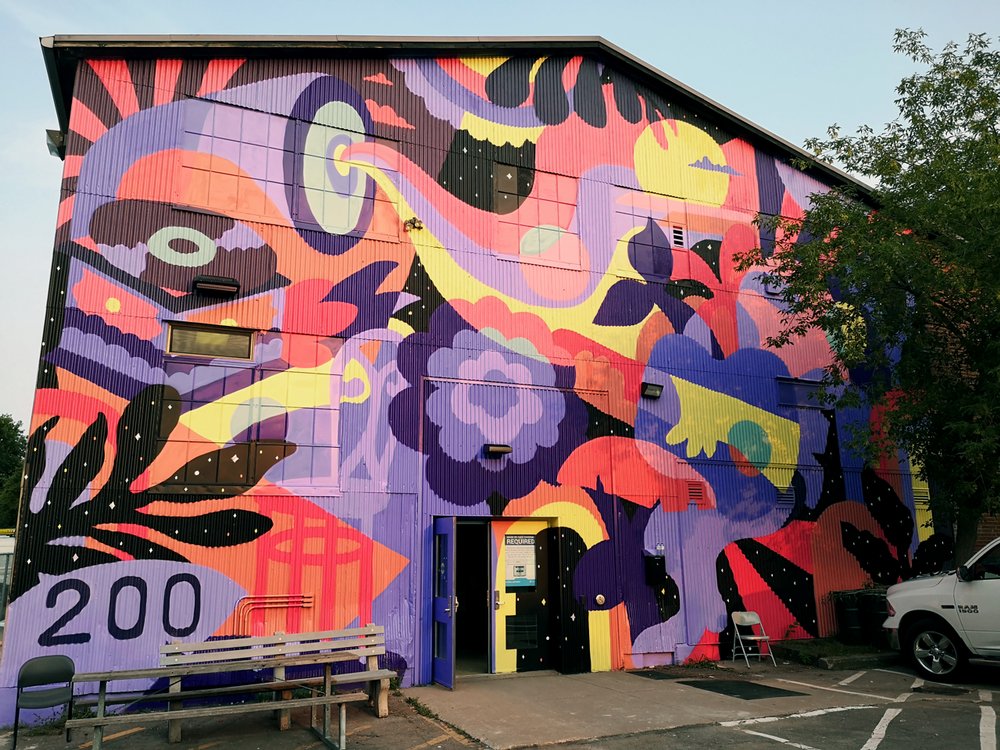 Vibrant purple, pink, and yellow mural cover the exterior of Bridgeworks.