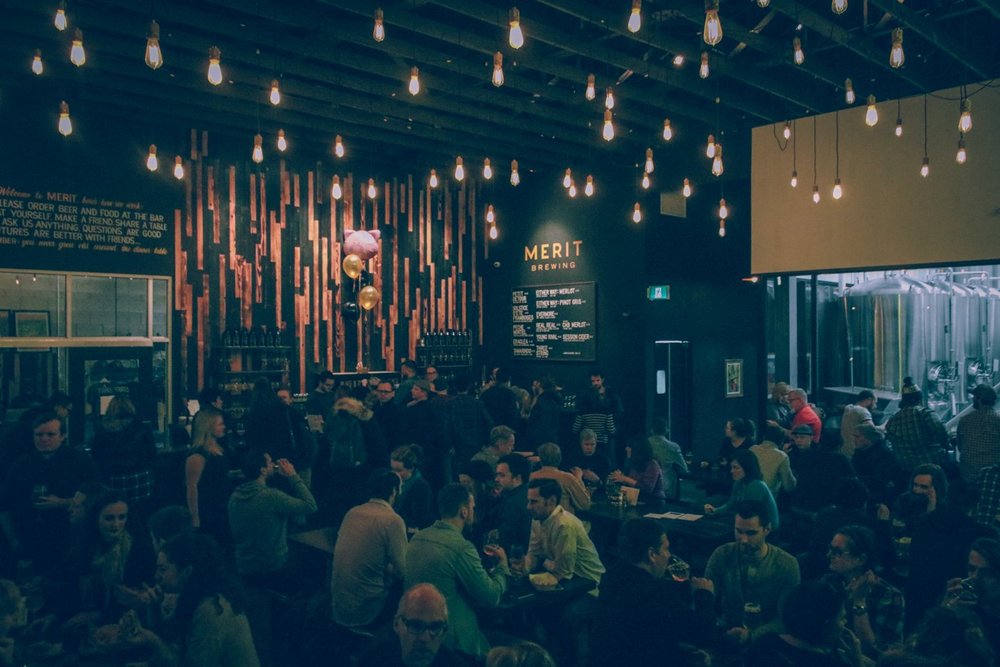 Interior of Merit Brewing full with people enjoying craft beer.