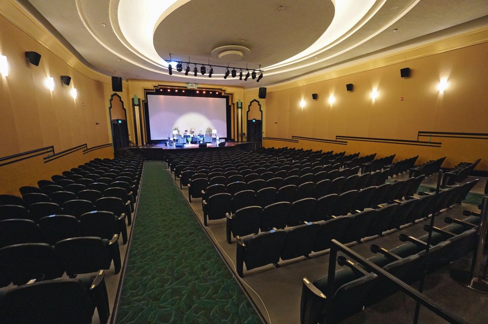 Inside auditorium of The Westdale before a show with yellow walls and green carpeting.