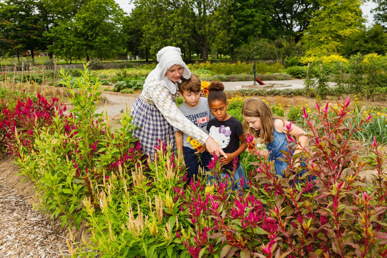 Visitors in garden with costumed interpreter