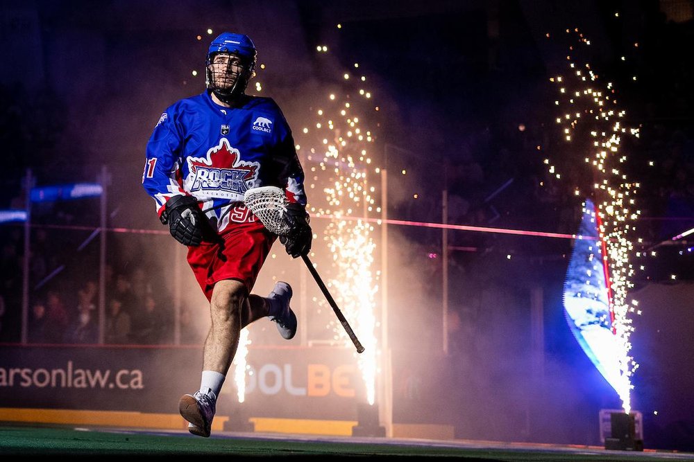 Rock player running onto field between fireworks at start of game.