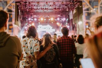 Young couple in a full crowd at Supercrawl watching a concert at night on the mainstage.