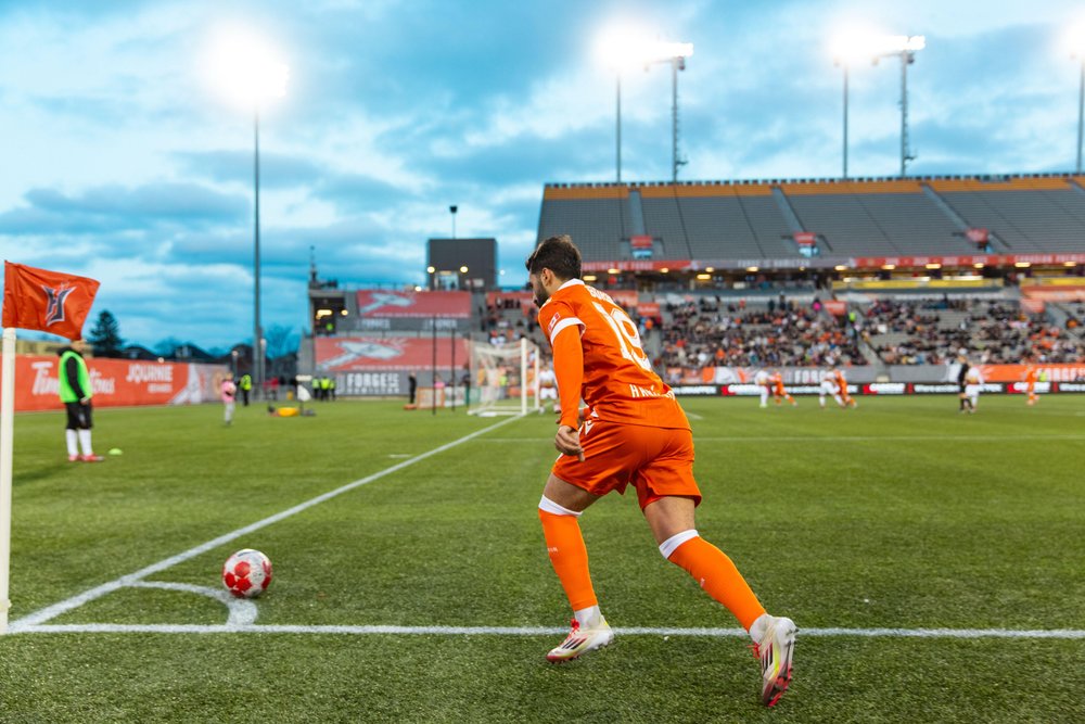 Forge FC player taking a corner kick.
