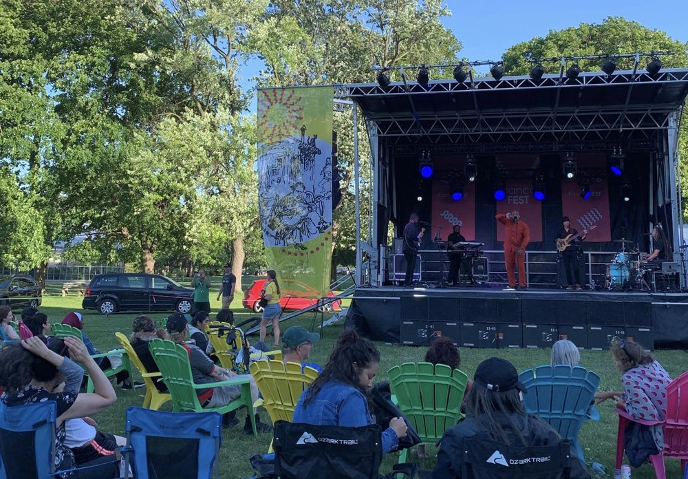 Stage set-up in Gage Park as performer entertains crowd.