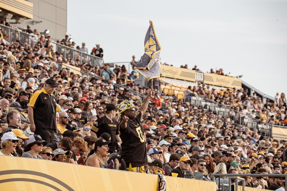 Fans cheering in stands at Tim Hortons Field.