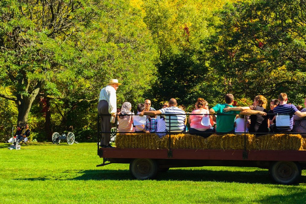 Adults and children on a hay wagon ride in Battlefield park.