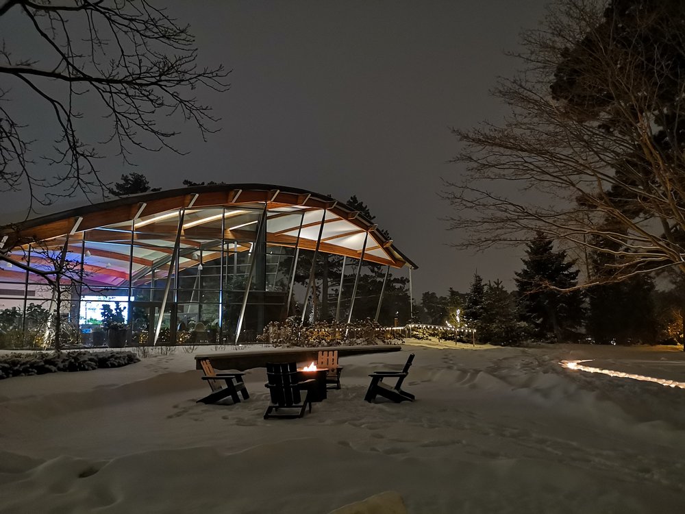 Exterior of RBG in winter with lights and roaring firepit.