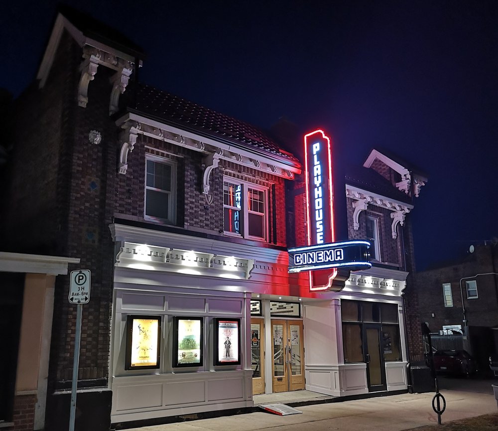 View of Playhouse Cinema from the street, lit up in the evening.