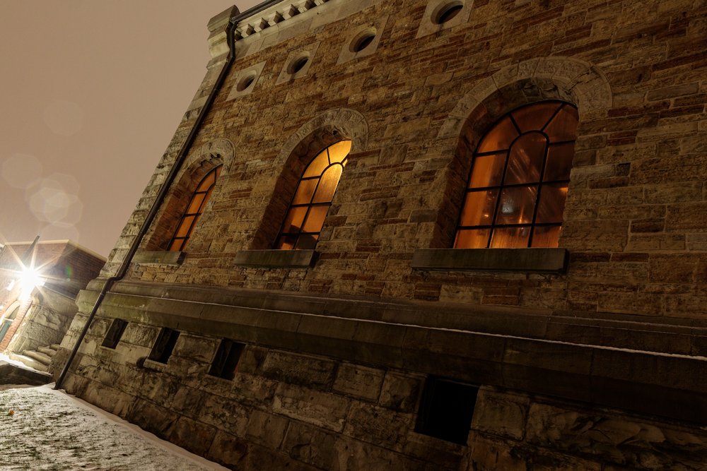 Exterior of Hamilton Museum of Steam & Technology at night with the glow of lights in the background.