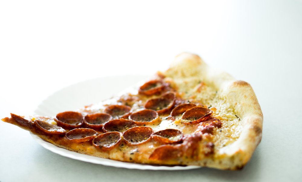 Slice of pepperoni pizza on a plate.