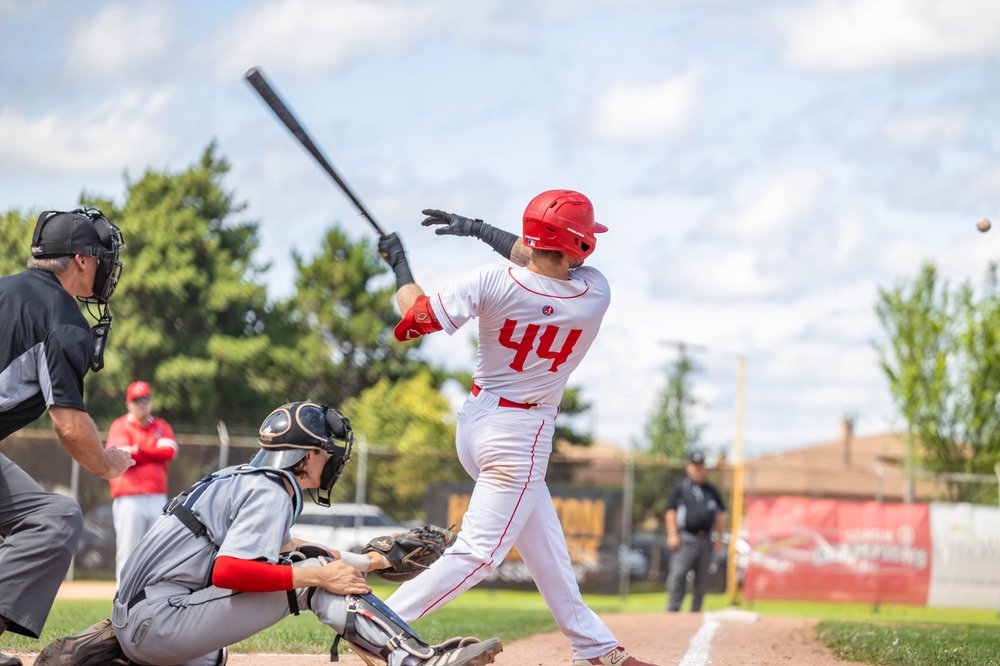 Cardinals player taking a swing at a pitch.