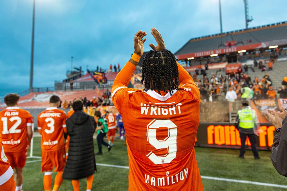 Forge FC player clapping his hands on the field