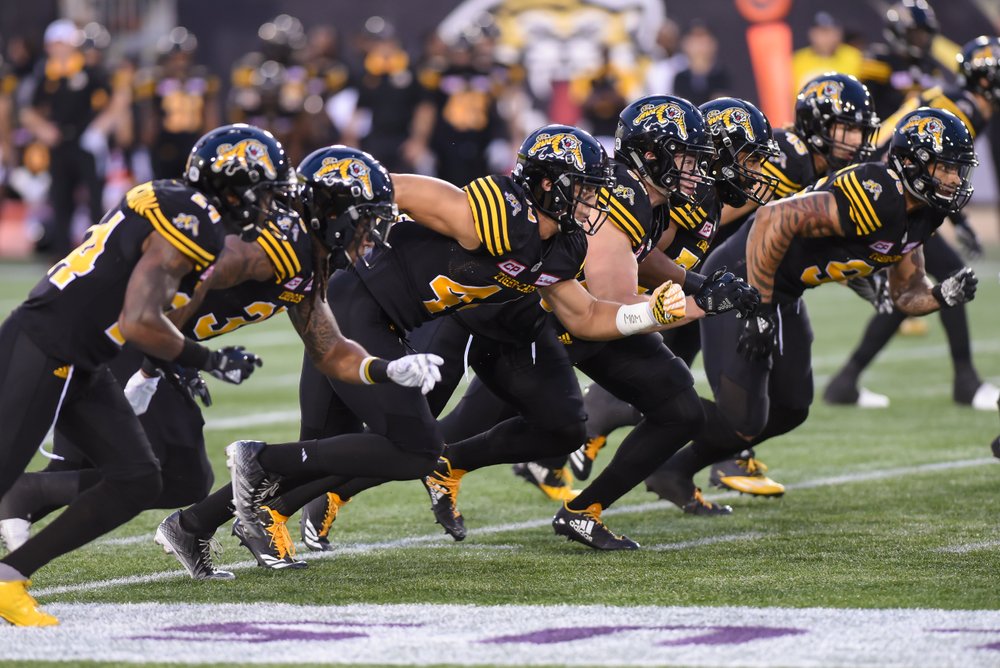 Ticats players on the field beginning the play.