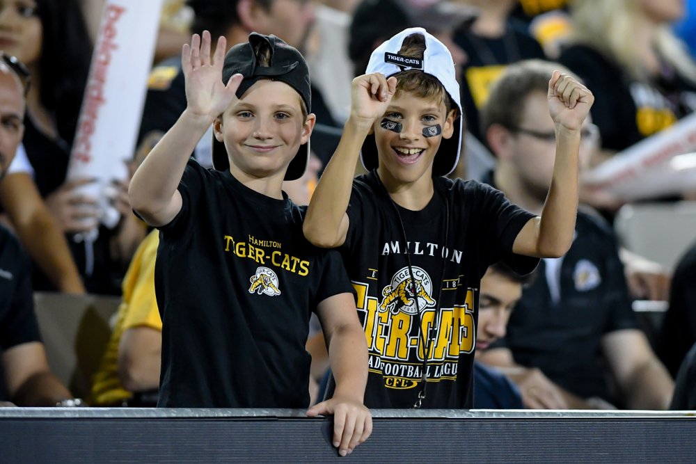 Kids in stands cheering on Tiger-Cats.
