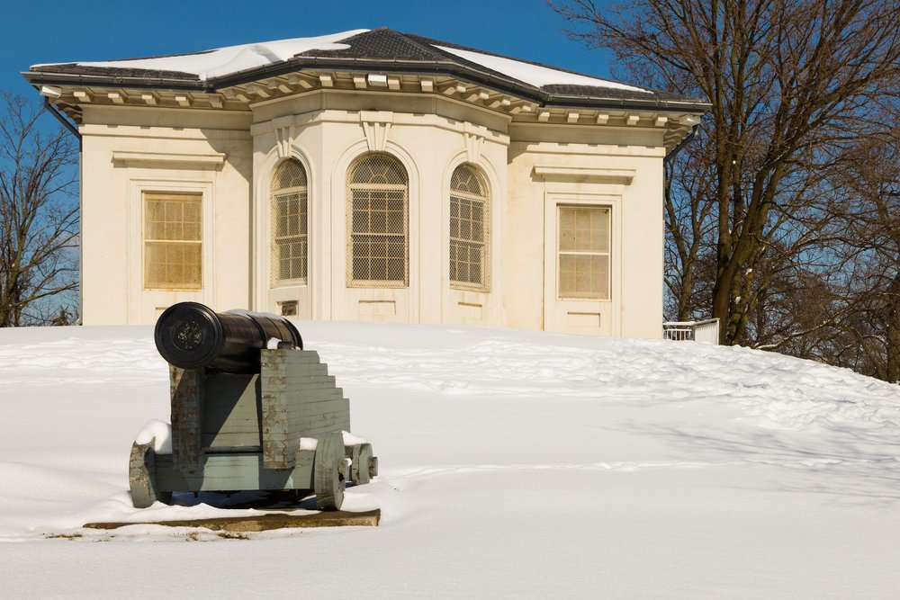 Cannon in front of a snow covered Hamilton Military Museum.