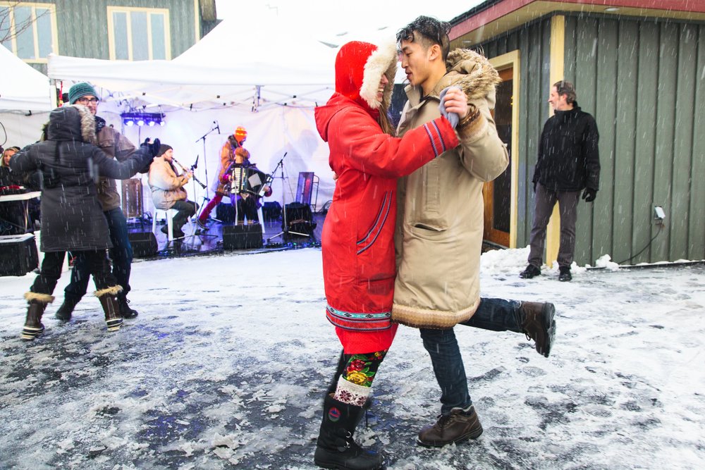 Couple dancing to live music at outdoor festival.