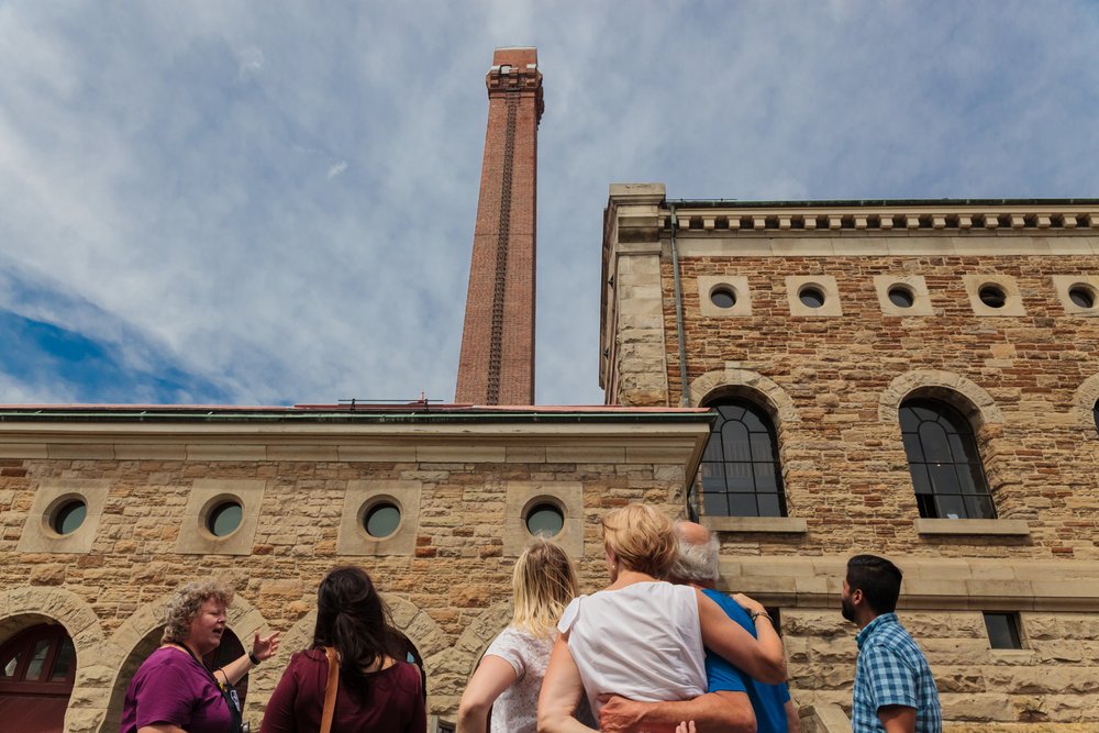 People standing outside Museum of Steam & Technology on a summer day.
