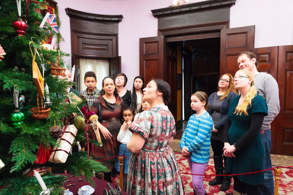 Visitors gathered around decorated Christmas tree at Dundurn Castle.